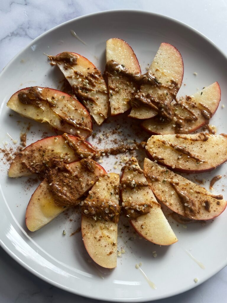 sliced apple with peanut butter for seed cycling